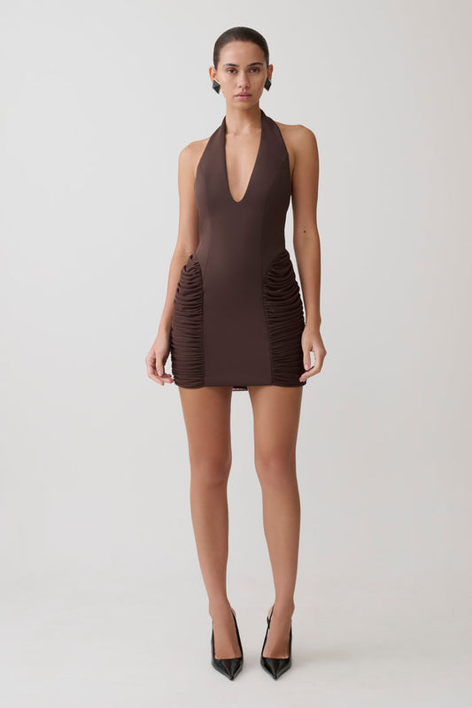 Woman wearing a brown halter neck mini dress.
