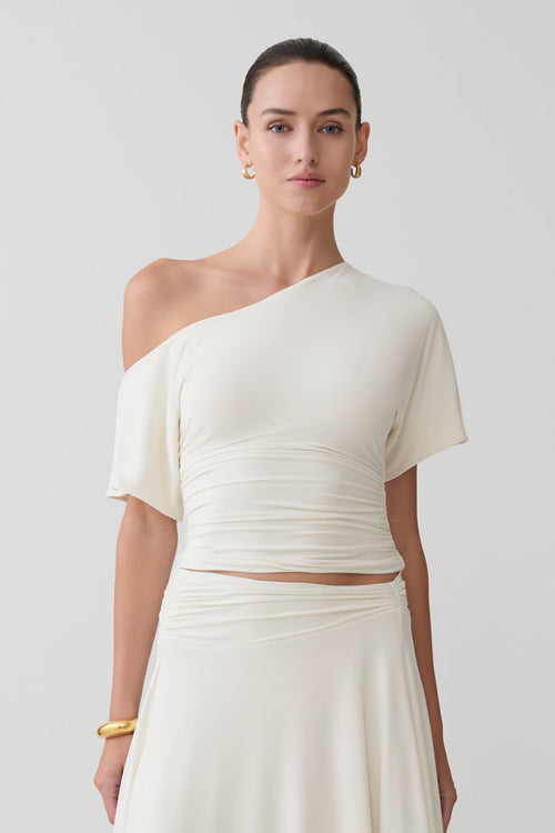 Woman wearing a white off-shoulder top.